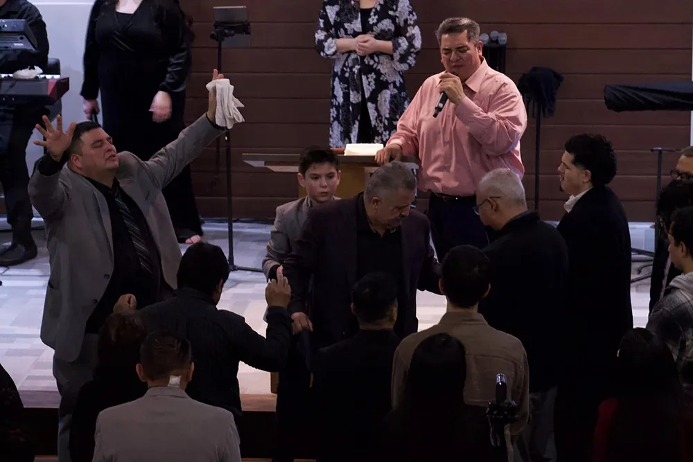 praying over one another at the altar at Casa de Dios Woodburn
