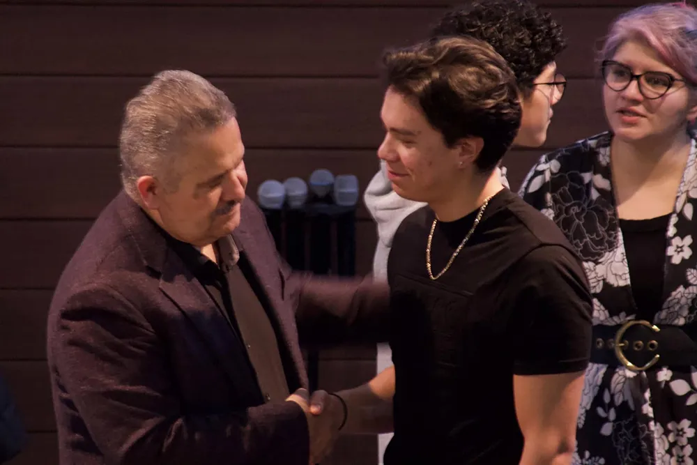 young man shaking the pastor's hand at Casa de Dios Woodburn